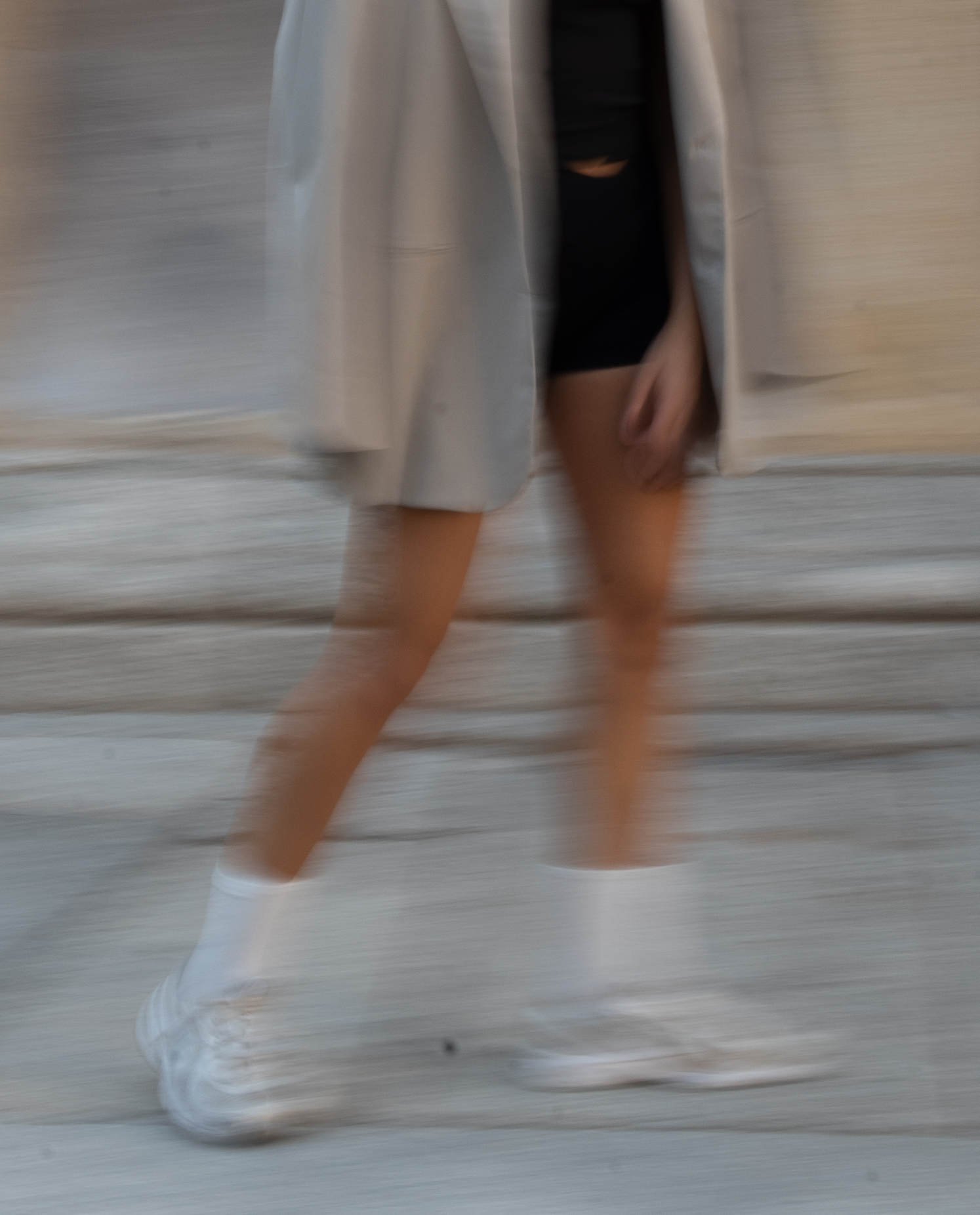 Woman in cream cardigan and black dress walking - TVS