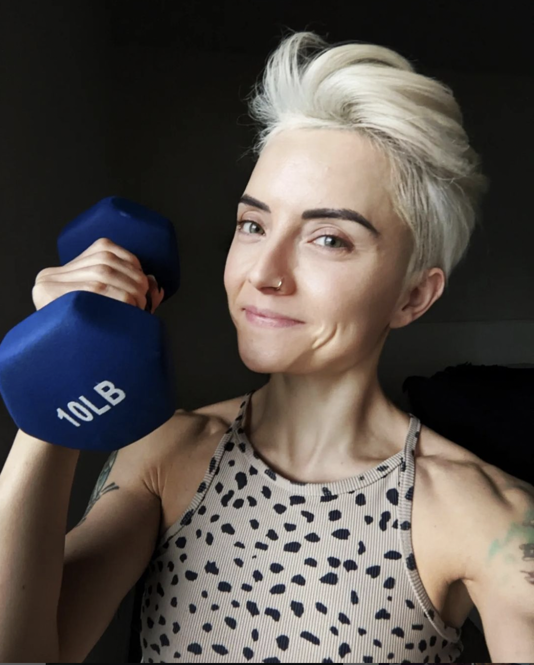 blonde, short haired author with a dumbell in hand