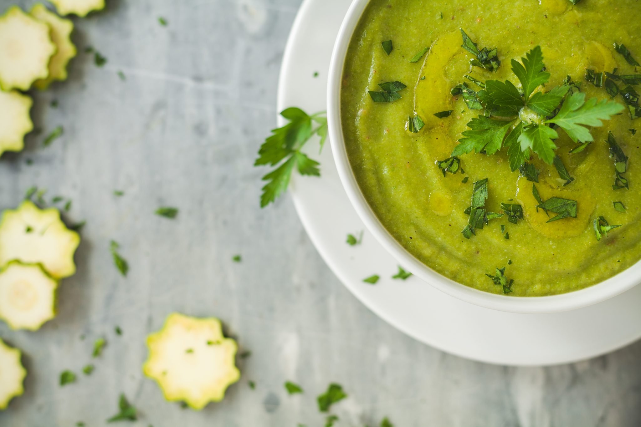 Green zucchini soup with zucchini slices on the side