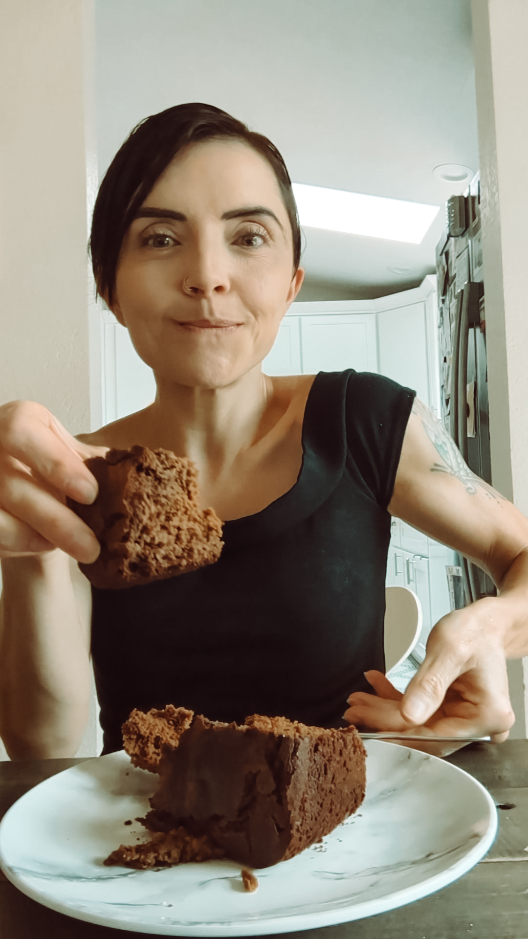 Woman (author) in a black top, enjoying brownies 