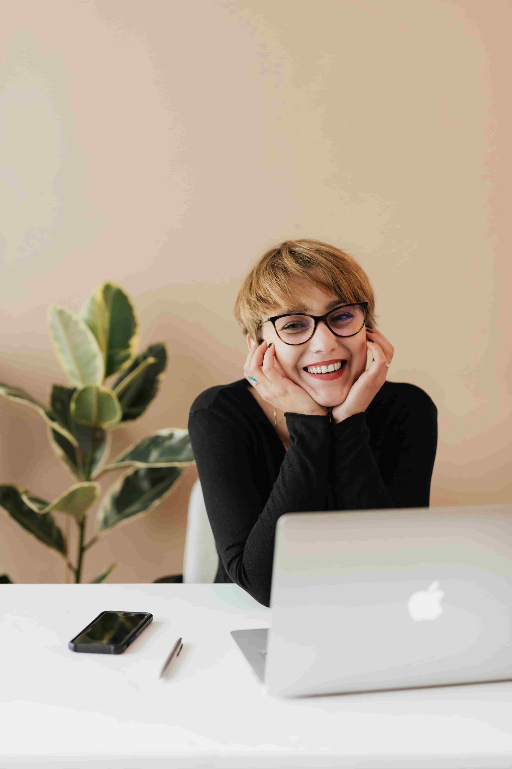 Woman, smiling, in front of a laptop