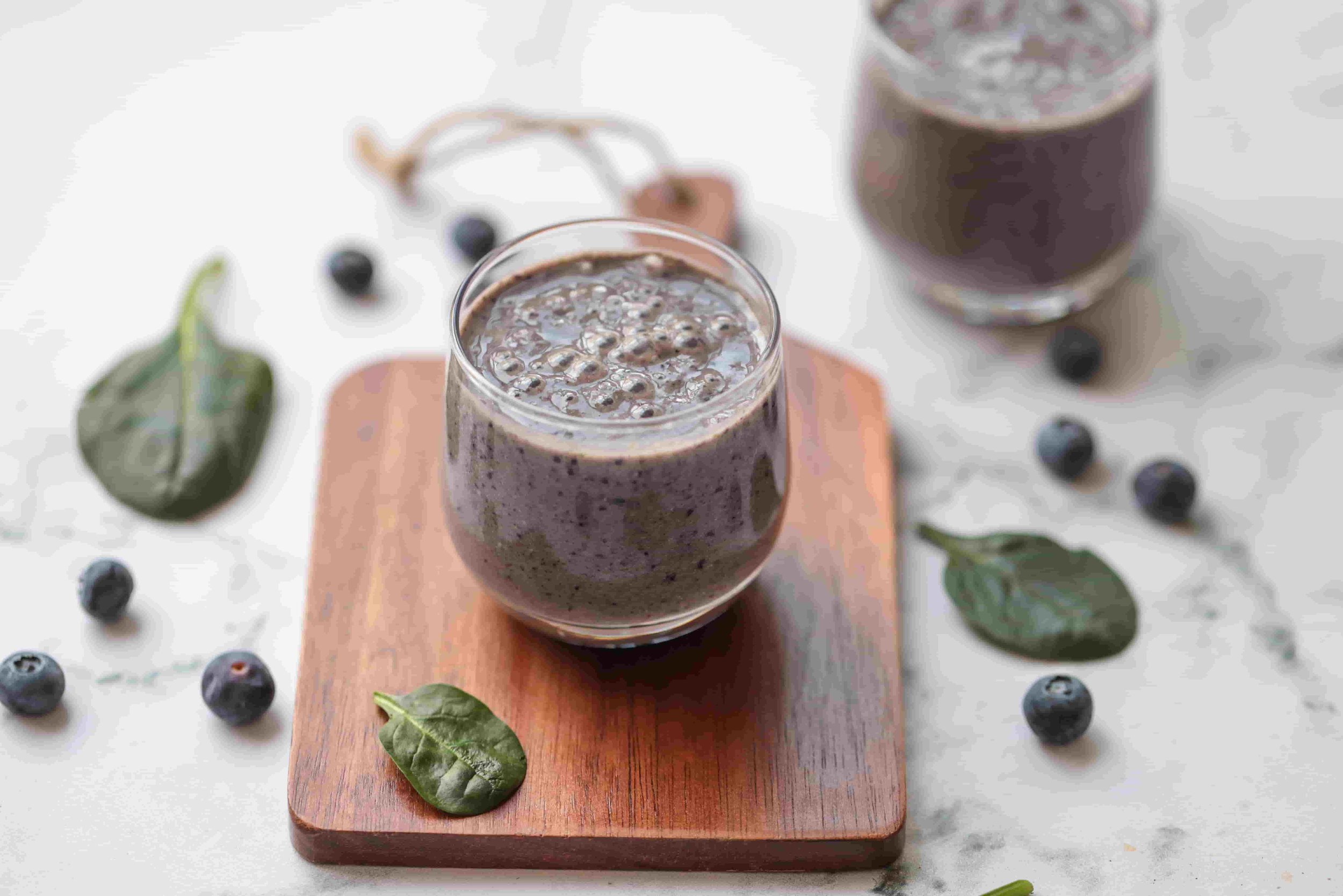 purple smoothie in a glass on a wooden surface