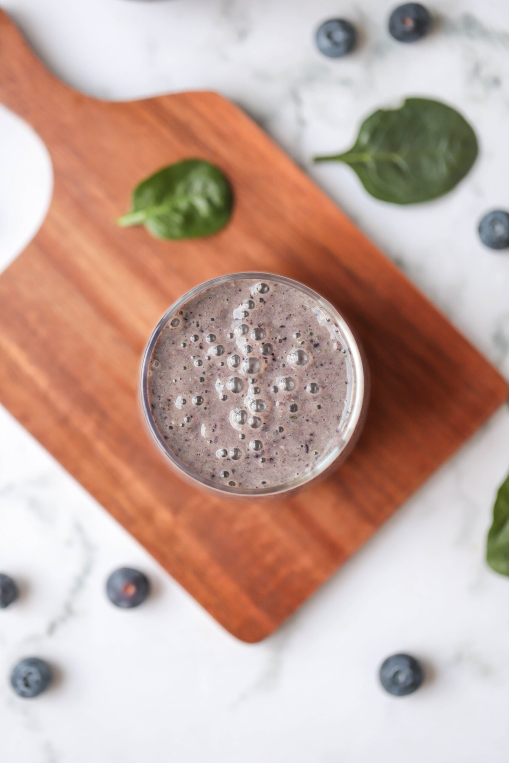 purple smoothie, bird eye view, spinach leaves next to it