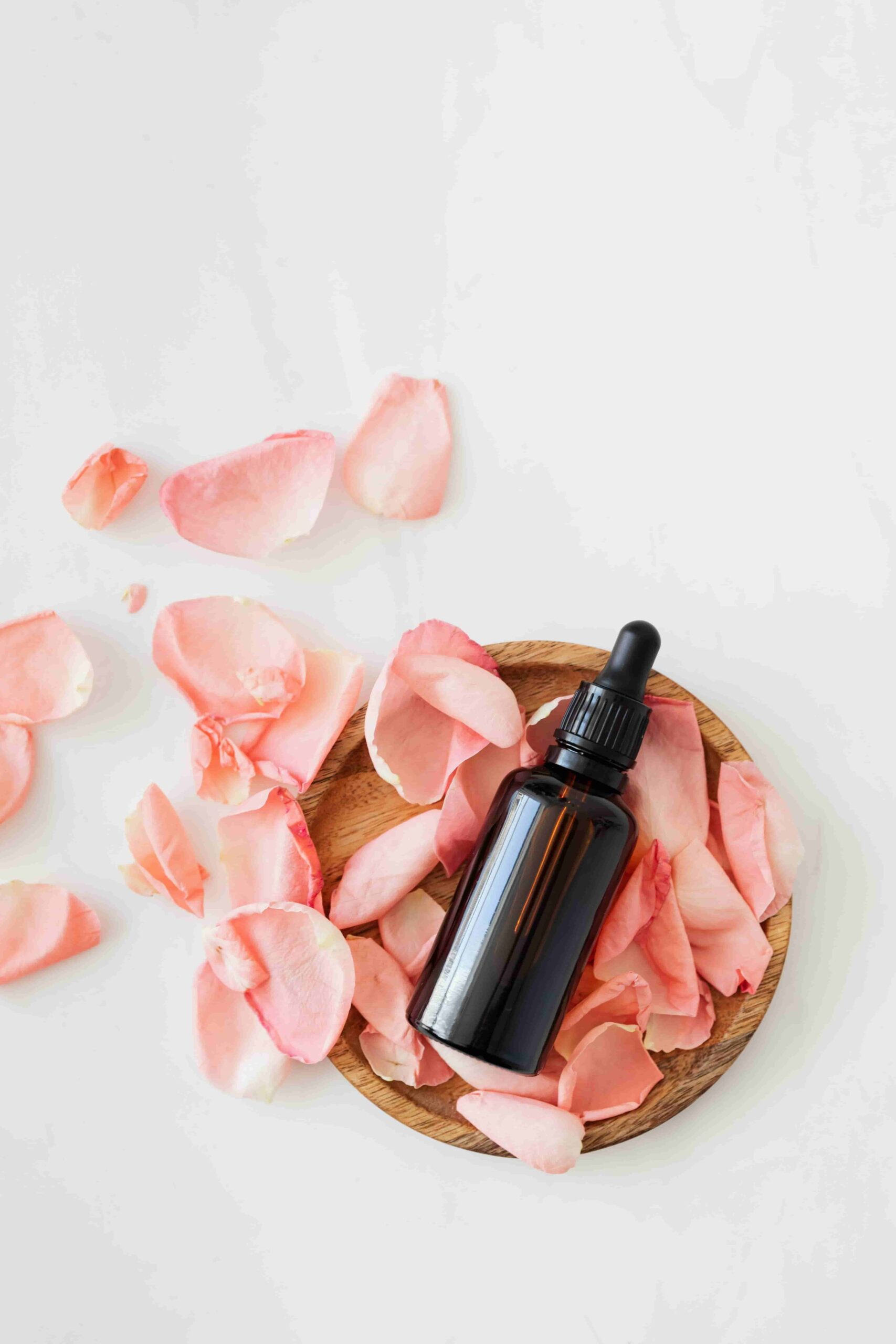 rose petals and a small amber-color bottle