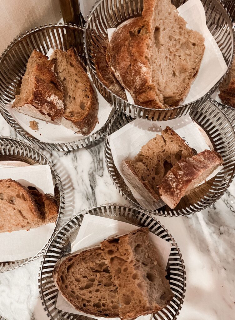 Artisanal whole wheat bread slices in metal baskets