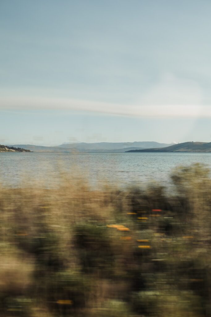 Subtle Moments - Serene coastal landscape with mountains and calm waters