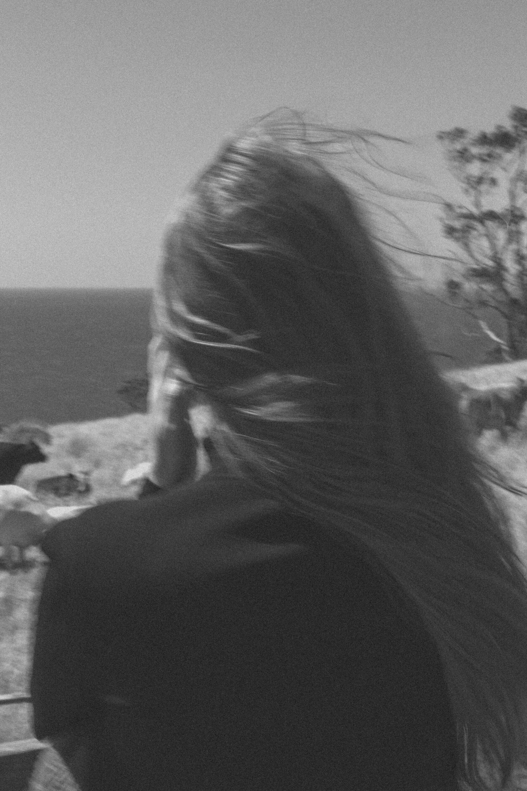 Dusk and Dawn - Woman with flowing hair gazing toward horizon by ocean - TVS