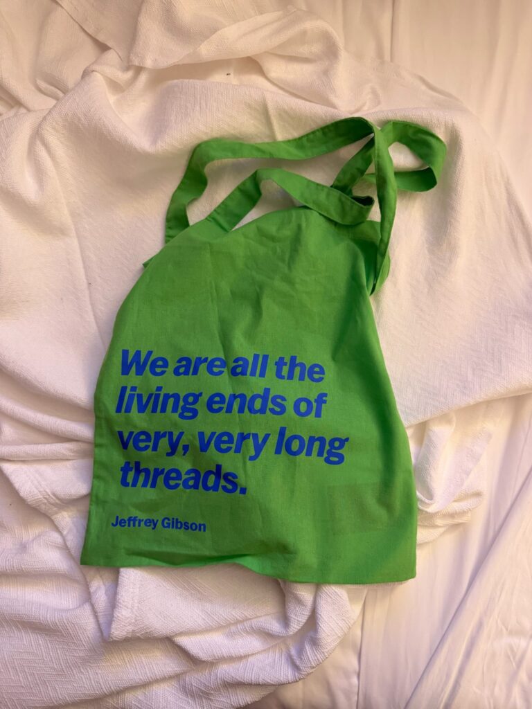 Green tote bag with Jeffrey Gibson quote on white fabric
