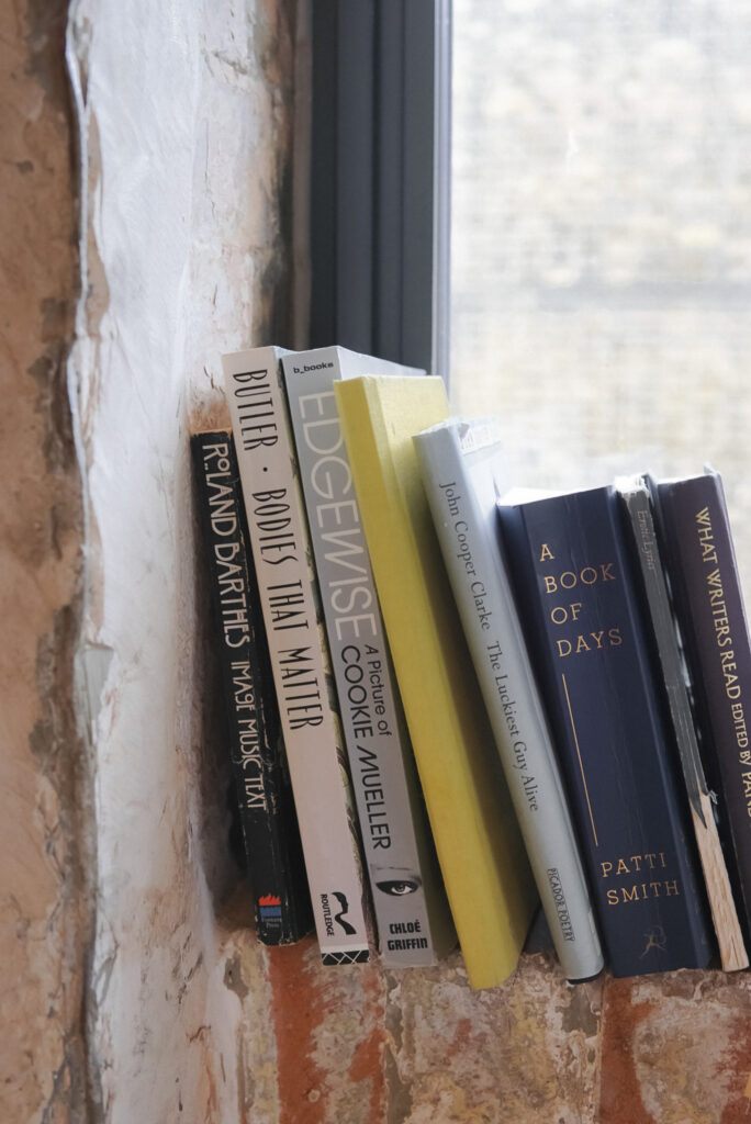 Stack of literary books displayed on rustic windowsill 