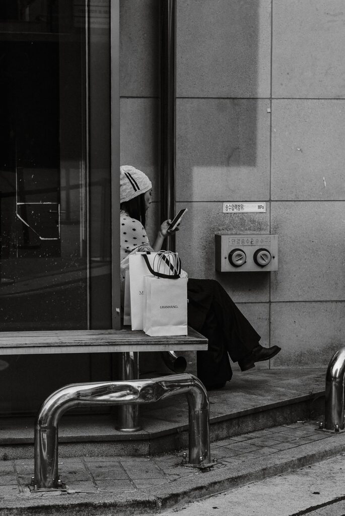 Woman sitting on bench with shopping bag_ waiting 