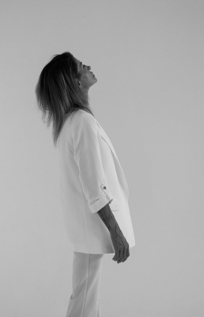 Woman in white blazer gazing upward_ minimalist portrait