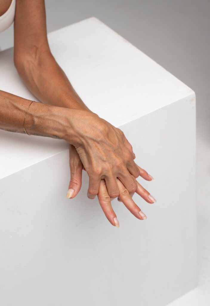 Woman_s hand touching smooth white sculptural surface